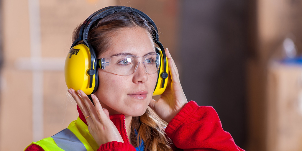 Woman wearing personal protective equipment eye goggles and ear covers