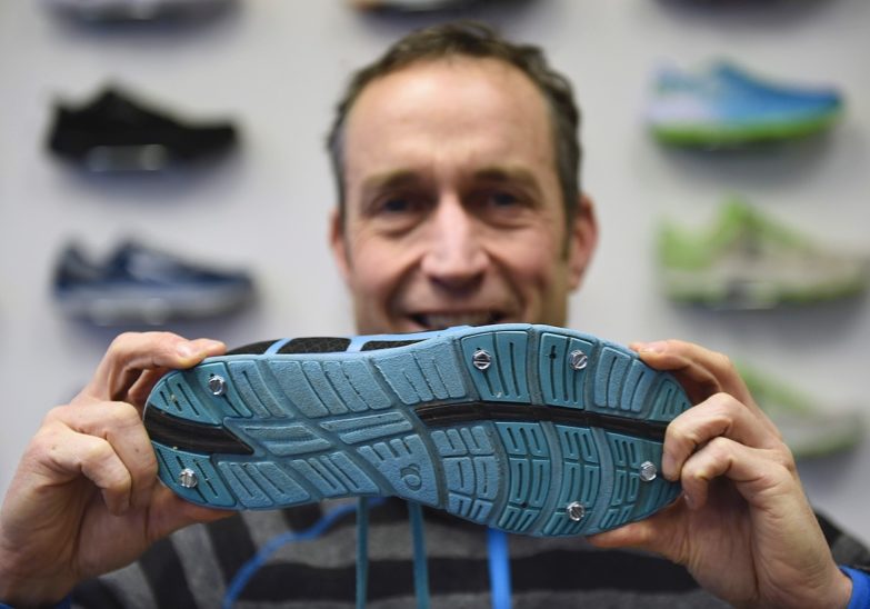 Dave Cressman of Distance Runwear shows running shoes with metal studs for running on snow